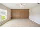 Modern bedroom with a wood accent wall, a ceiling fan, and a large window overlooking the yard at 383 Blue Lake Cir, Kissimmee, FL 34758