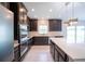 The modern kitchen features stainless appliances, an island, and sleek dark cabinets at 383 Blue Lake Cir, Kissimmee, FL 34758