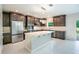 Modern kitchen with stainless steel appliances, dark cabinets, a center island, and light countertops at 383 Blue Lake Cir, Kissimmee, FL 34758