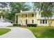 Inviting yellow two-story home featuring a covered porch, neat landscaping, and a curved driveway at 1226 Se 9Th Ave, Ocala, FL 34471