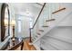 Bright foyer with hardwood floors, elegant staircase, and stylish mirror creating a welcoming entrance at 1226 Se 9Th Ave, Ocala, FL 34471