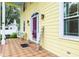 Charming front porch with brick tile flooring, a vibrant purple door, and a cozy seating area at 1226 Se 9Th Ave, Ocala, FL 34471