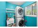 Laundry room with stacked washer and dryer, utility sink, and natural light from a window at 1226 Se 9Th Ave, Ocala, FL 34471