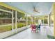 Enclosed porch boasts a view of the garden and features chairs around a table, ceiling fan, and bright colors at 1226 Se 9Th Ave, Ocala, FL 34471
