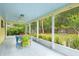 Enclosed porch boasts a view of the garden and features chairs around a table, ceiling fan, and bright color at 1226 Se 9Th Ave, Ocala, FL 34471