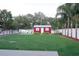 Expansive backyard with a shed, white fence, well-maintained lawn, and mature trees at 1423 Spruce N Rd, Lakeland, FL 33809