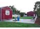 Large shed with a metal roof and well maintained lawn, with mature trees and a white fence at 1423 Spruce N Rd, Lakeland, FL 33809