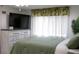 Bedroom features a TV atop a dresser, accented by tropical-themed curtains at 1423 Spruce N Rd, Lakeland, FL 33809