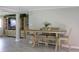 Dining room featuring a light wood table with cushioned chairs, entertainment center, and gray tile flooring at 1423 Spruce N Rd, Lakeland, FL 33809