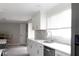 Updated kitchen features white cabinets, stainless steel appliances, quartz countertops, and gray wood-look floors at 1423 Spruce N Rd, Lakeland, FL 33809