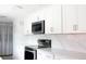 Kitchen features stainless steel appliances, white cabinets, quartz countertops, and a view of the dining area at 1423 Spruce N Rd, Lakeland, FL 33809