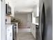 Updated kitchen with stainless steel appliances, quartz countertops, a view of the dining area, and white cabinetry at 1423 Spruce N Rd, Lakeland, FL 33809