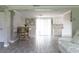 Bright living room with gray floors, kitchen, dining area, and sliding glass doors leading to the outside at 1423 Spruce N Rd, Lakeland, FL 33809