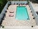 Arial shot of backyard fenced-in pool with outdoor lounge furniture and landscaping at 1423 Spruce N Rd, Lakeland, FL 33809
