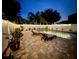 Relaxing pool area with pavers, chairs, tasteful plantings, and a privacy fence with lights for ambiance at 1423 Spruce N Rd, Lakeland, FL 33809