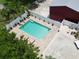 Aerial view of backyard pool with brick trim, surrounded by a white fence and potted plants at 1423 Spruce N Rd, Lakeland, FL 33809