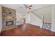 Cozy living room with a stone fireplace, wood floors, and staircase with tile accents at 2283 Geneva Dr, Lakeland, FL 33805