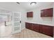 Pantry featuring tile floors, brown cabinets, and a white countertop, located off the kitchen at 2283 Geneva Dr, Lakeland, FL 33805