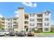 Exterior view of a multi-story condo building showcasing balconies, parking, and well-kept landscaping at 3175 Feltrim Pl # 405, Kissimmee, FL 34747
