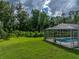 Expansive green backyard with an enclosed pool area surrounded by lush foliage at 3952 Laurel Branch Dr, Lakeland, FL 33810