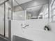 Bright bathroom featuring a glass shower, large tub, and a arched window at 3952 Laurel Branch Dr, Lakeland, FL 33810