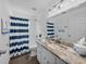 White bathroom with blue and white shower curtain and granite countertop sink at 3952 Laurel Branch Dr, Lakeland, FL 33810