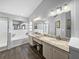 Bright bathroom featuring a double vanity, a bathtub and shower, all illuminated by modern lighting fixtures at 3952 Laurel Branch Dr, Lakeland, FL 33810