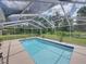 Screened-in pool with a blue tile border, surrounded by a concrete deck and lush green lawn at 3952 Laurel Branch Dr, Lakeland, FL 33810