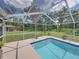 Screened-in pool with a blue tile border, surrounded by a concrete deck and lush green lawn at 3952 Laurel Branch Dr, Lakeland, FL 33810