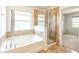 Bright bathroom featuring a tub, glass-enclosed shower, and tiled floor at 1769 Strathmore Cir, Mount Dora, FL 32757
