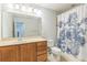 This bathroom features a large vanity with a neutral countertop and a shower with a decorative floral curtain at 1769 Strathmore Cir, Mount Dora, FL 32757