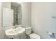 Clean bathroom featuring a pedestal sink, toilet, mirror, and a shower with glass door at 1769 Strathmore Cir, Mount Dora, FL 32757
