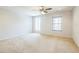 Bright, airy carpeted bedroom with ceiling fan and windows allowing for ample natural light at 1769 Strathmore Cir, Mount Dora, FL 32757