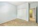 Cozy bedroom featuring carpeted floors, bi-fold closet doors, and an adjacent door to another room at 1769 Strathmore Cir, Mount Dora, FL 32757