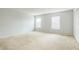 A spacious bedroom with neutral carpet, two windows, and a closet, offering ample storage and natural light at 1769 Strathmore Cir, Mount Dora, FL 32757