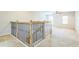 Well-lit landing featuring wood and iron railings, and neutral carpet extending into adjacent rooms at 1769 Strathmore Cir, Mount Dora, FL 32757