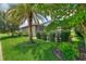 Serene backyard with a screened lanai, mature palm trees, and lush landscaping for privacy at 224 Granada Ln, Davenport, FL 33837