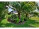 Lush tropical backyard with a screened lanai, mature palm trees, and manicured landscaping for a private oasis at 224 Granada Ln, Davenport, FL 33837
