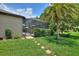 Lush backyard with stepping stones leading to a screened-in lanai and well-manicured landscaping at 224 Granada Ln, Davenport, FL 33837