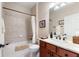 Well-lit bathroom features a vanity with cherry cabinets, a shower-tub combination, and tile flooring at 224 Granada Ln, Davenport, FL 33837