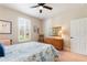 Bedroom featuring plantation shutters, warm wall color, a ceiling fan, and soft carpet at 224 Granada Ln, Davenport, FL 33837