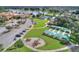 Aerial view of community amenities, including tennis courts, bocce ball, playground, and parking at 224 Granada Ln, Davenport, FL 33837
