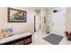 Bright entryway with tiled floor, a decorative bench and artwork, leading to other rooms at 224 Granada Ln, Davenport, FL 33837