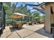 Enclosed patio with multiple seating areas, outdoor kitchen, and lush greenery at 224 Granada Ln, Davenport, FL 33837