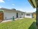 Backyard featuring a well-maintained lawn and a single-story home, with a side shed and a hose at 3100 Peacock Ln, Mulberry, FL 33860