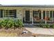 Inviting front porch with seating, flower planters, and a decorative wreath on the front door at 3100 Peacock Ln, Mulberry, FL 33860