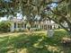Charming home with lush lawn, brick accents, and a relaxing hammock hanging from a tree at 3100 Peacock Ln, Mulberry, FL 33860