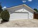 Detached garage with white siding and a large roll-up door, plus an adjacent fenced yard at 3100 Peacock Ln, Mulberry, FL 33860