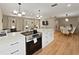 Spacious kitchen with an island, stainless steel oven, and hardwood floors connects to the dining and living areas at 3100 Peacock Ln, Mulberry, FL 33860
