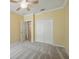 This carpeted bedroom offers a ceiling fan and a double door closet at 442 Graystone Blvd, Davenport, FL 33837